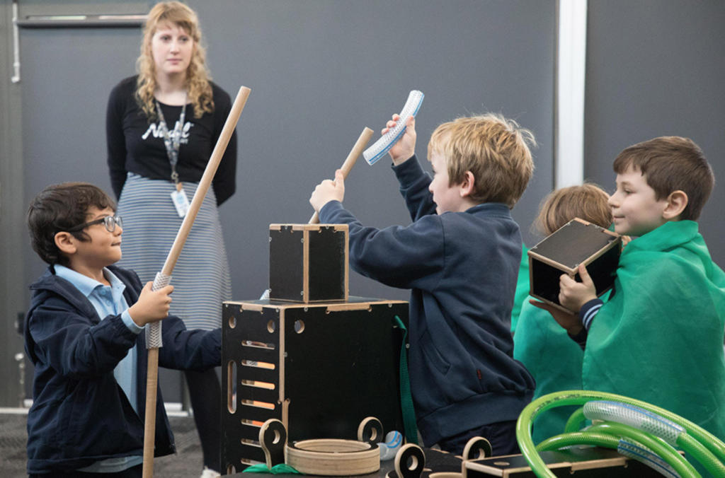 Children playing and engaged with a Nüdel Kart with the adult "observing" not directing the play
